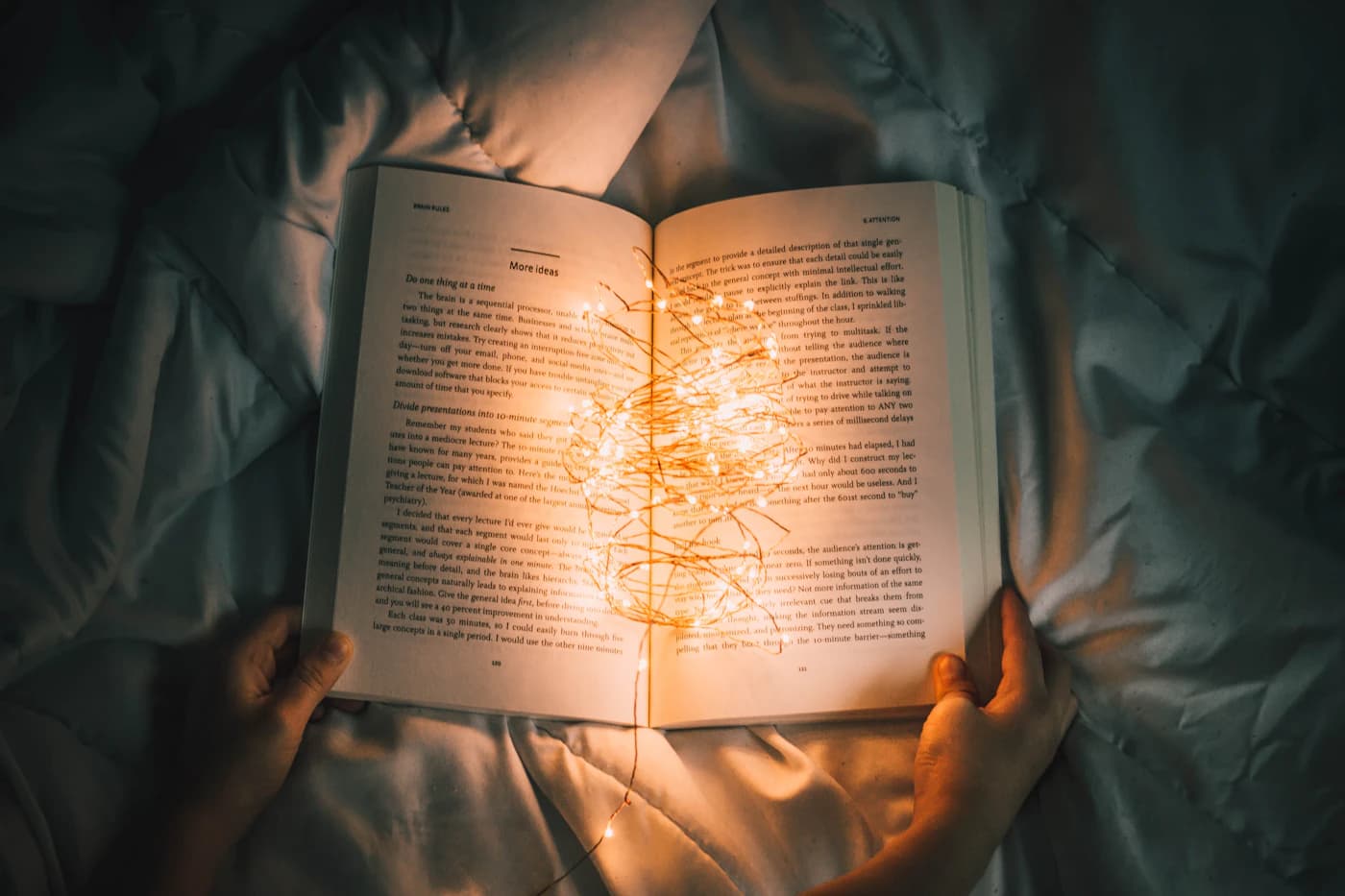 کتابی که نورهای ریز دورش را گرفته‌اند، در تاریکی اتاق