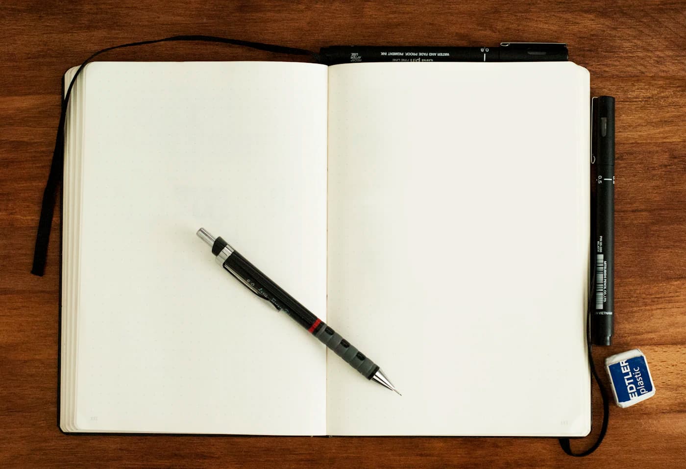 دفتر یادداشت باز با مداد روی میز؛ آمادهی نوشتن اولین صفحه